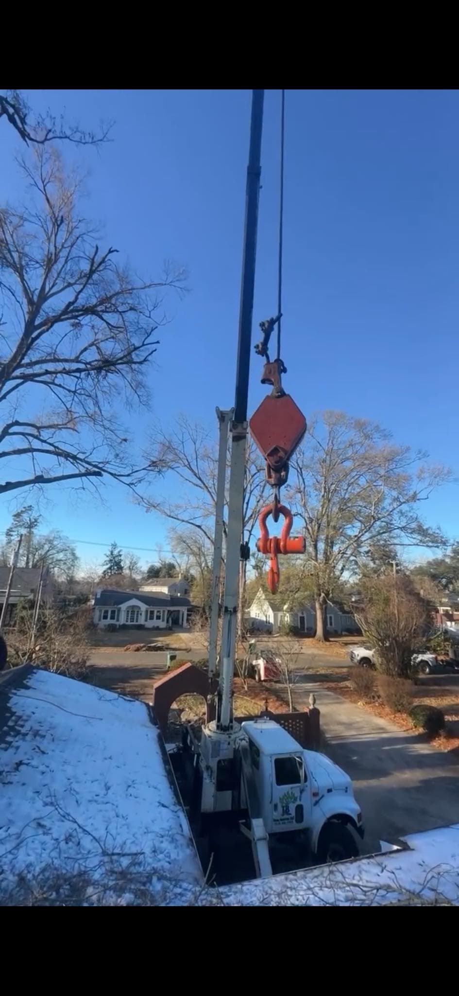 Crane truck staged during tree work in winter conditions