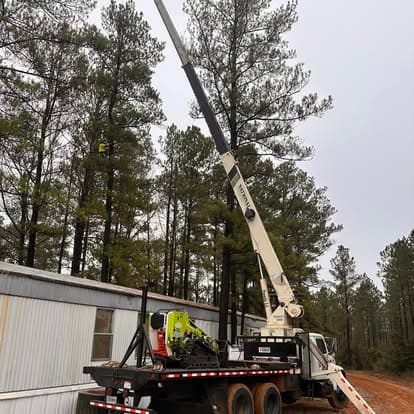 Crane setup for tree removal near a home