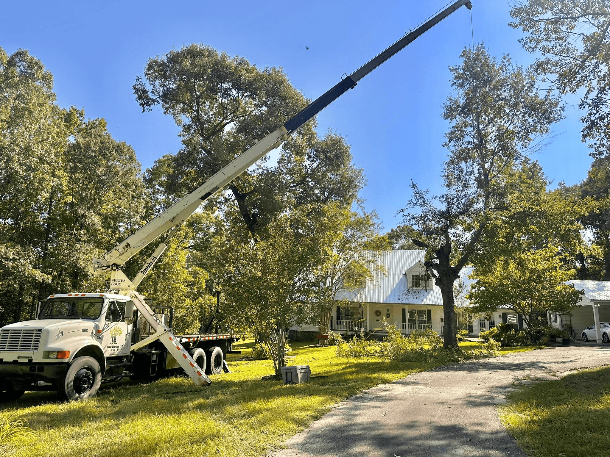 Crane setup on a rural property near a farmhouse