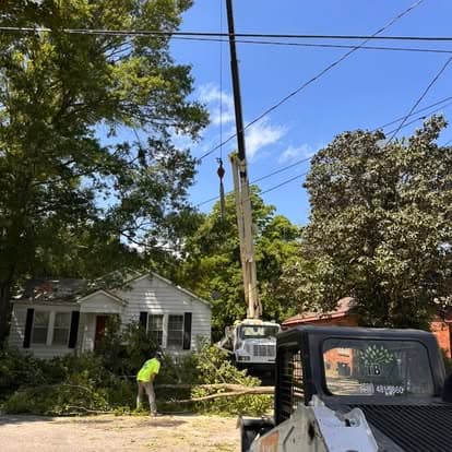 Crane and skid steer working together on debris cleanup