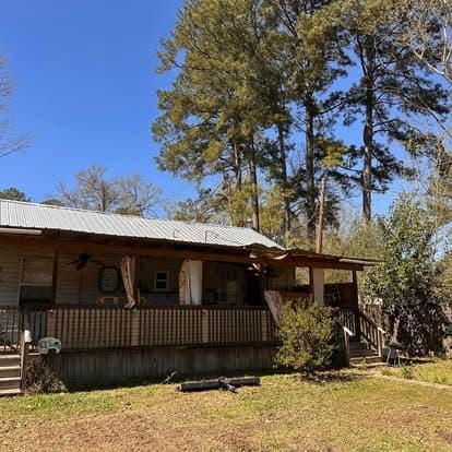 House surrounded by tall pine trees requiring difficult access removal